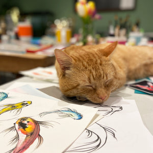 Ginger cat snoozing on top of artwork after a Suzanne Pink art workshop