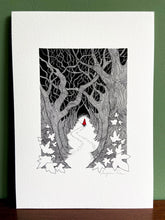 Load image into Gallery viewer, Red Riding Hood giclée print with handpainted watercolour detail in red, standing on wooden surface with green wall behind.