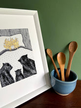 Load image into Gallery viewer, Goldilocks giclée print with handpainted gold gouache hair detail. Print is in a white frame, standing on a wooden surface with green wall behind. Bowl with three wooden spoons stands beside.