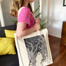 Load image into Gallery viewer, Red Riding Hood canvas tote bag being carried over the shoulder by a girl wearing a pink t-shirt in a living room with a wooden floor.
