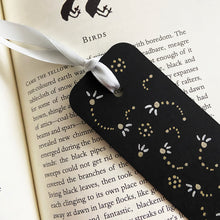 Load image into Gallery viewer, Black bookmark with a gold and silver dotted design and a silver ribbon on an open book.