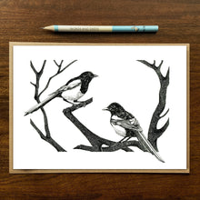 Load image into Gallery viewer, magpies greetings card on wood background with recycled kraft envelope and pencil.