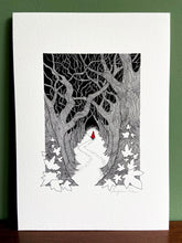 Load image into Gallery viewer, Red Riding Hood giclée print with handpainted watercolour detail in red, standing on wooden surface with green wall behind. 

