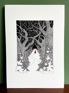 Red Riding Hood giclée print with handpainted watercolour detail in red, standing on wooden surface with green wall behind. 