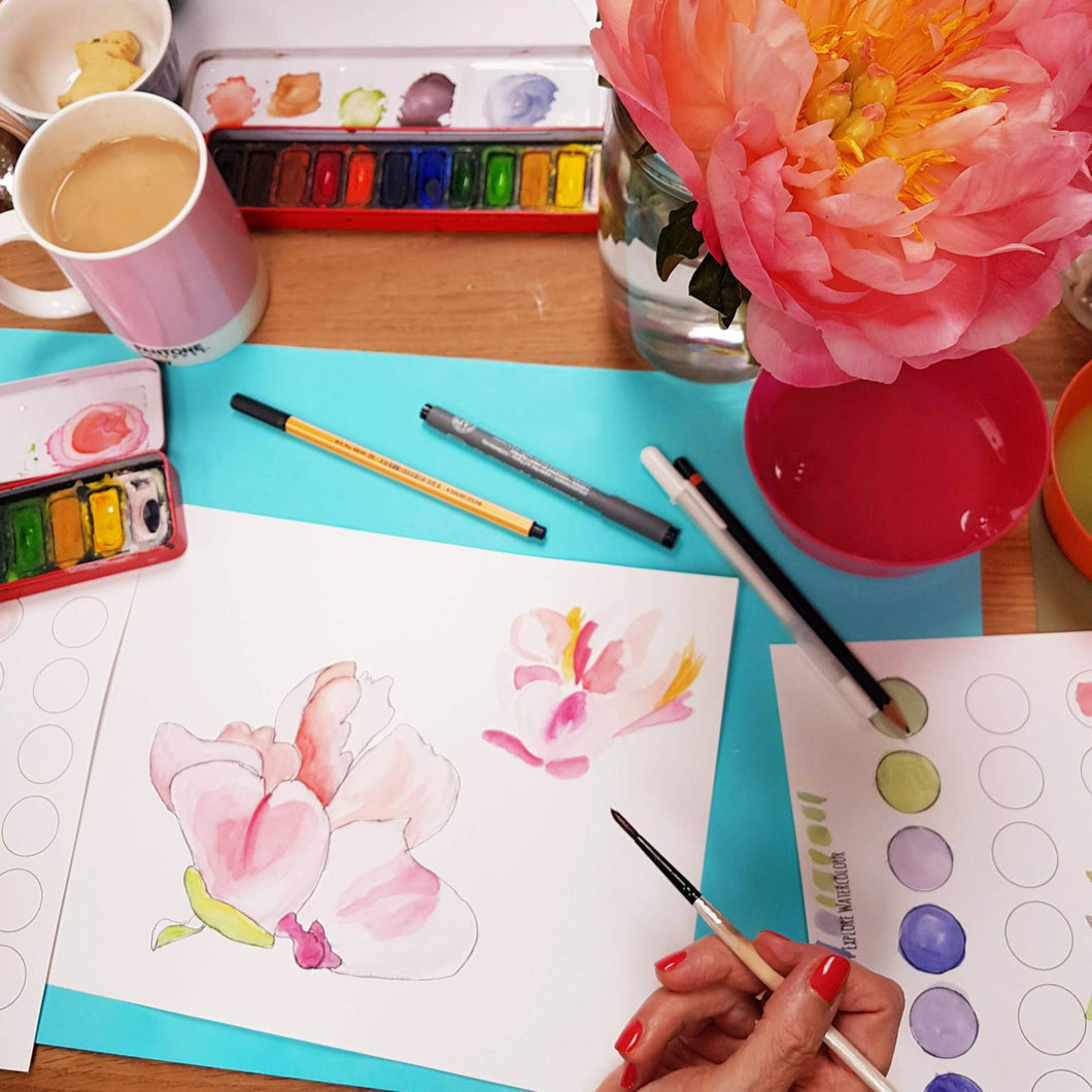 Floral painting in an adult workshop with a mug of tea and paint set.