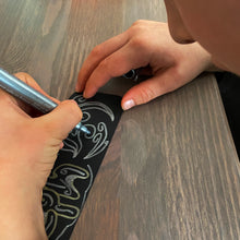 Load image into Gallery viewer, Child drawing a pattern design on a bookmark using a silver marker pen.
