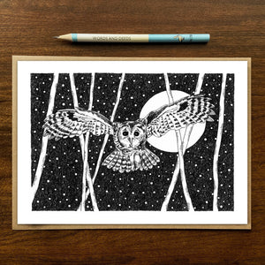 Swooping owl greetings card on wooden background with recycled kraft envelope and pencil.